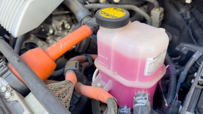 Car coolant reservoir full of pink antifreeze