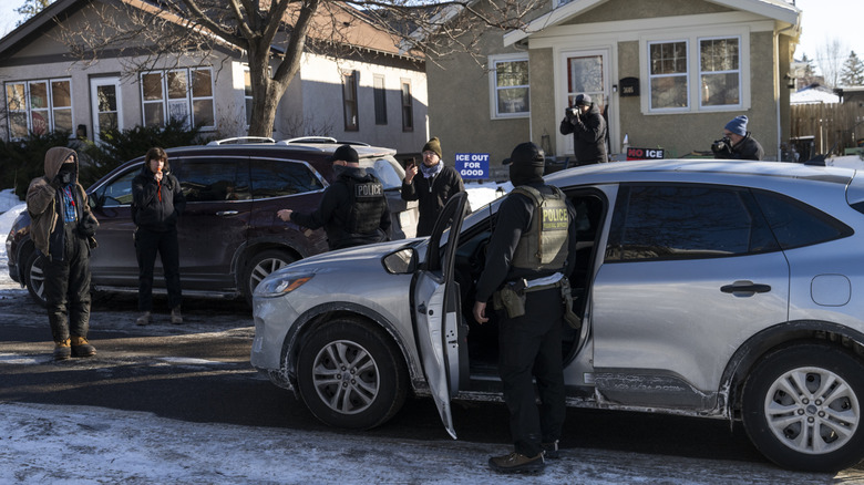 ICE agents get out of their vehicle to warn observers on January 30, 2026 in Minneapolis, Minnesota.