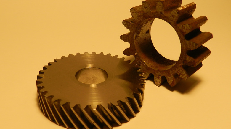 An example of helical and straight cut gear designs sitting on a golden-yellow background