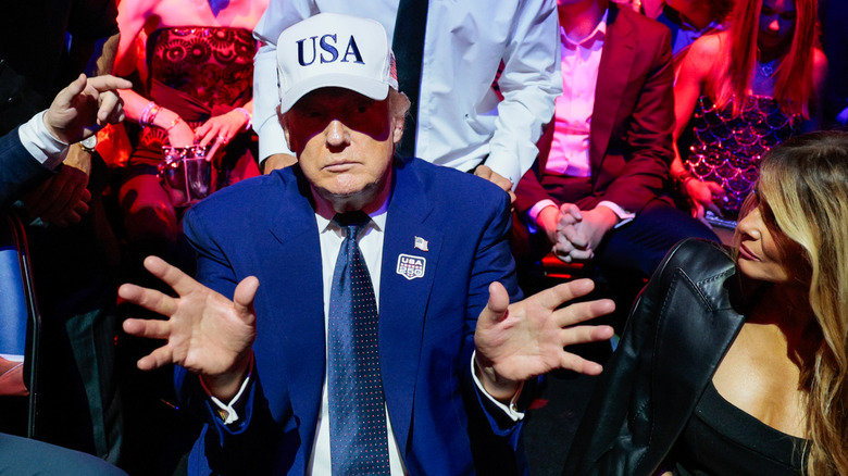 President Trump at the UFC event wearing a USA hat and holding his hands like "it's just an illusion."