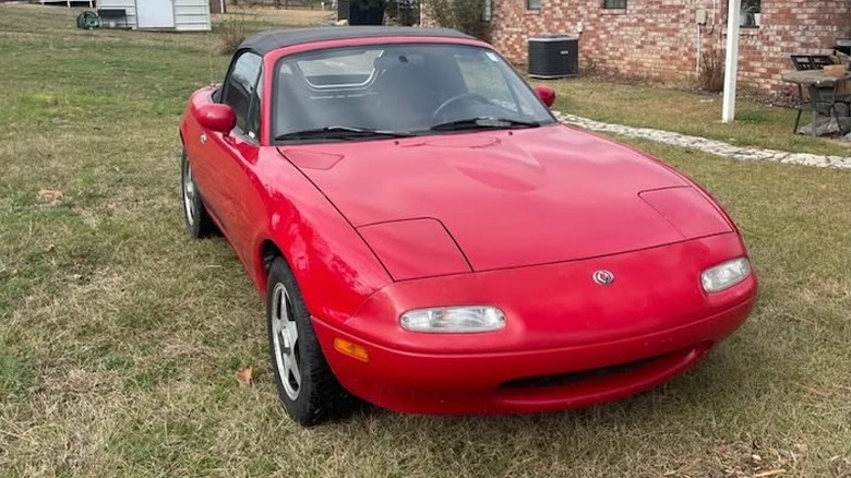 Front 3/4 view of a red 1997 Mazda Miata for sale on Facebook Marketplace