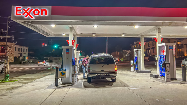 An SUV at an Exxon station at night.