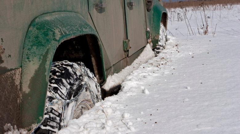 Winter chains for cars seen on a vehicle parked in snow.