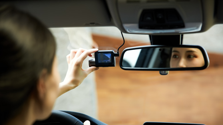 Woman adjusting her dashcam.