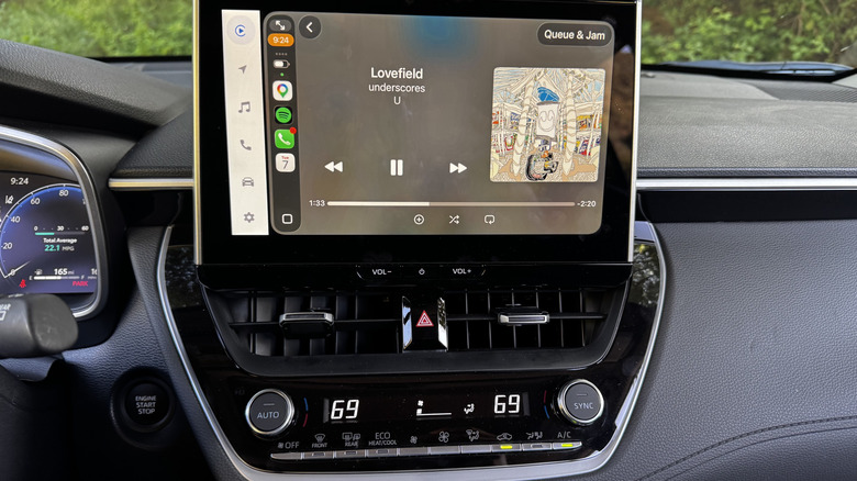 A close-up of the center stack showing Apple CarPlay up and the dual-zone climate control set to 69-degrees.