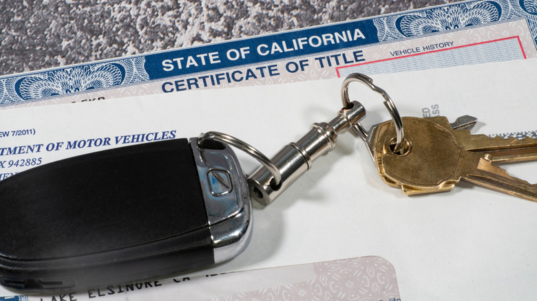 A close-up of a California title sheet with a car key placed on top of it.