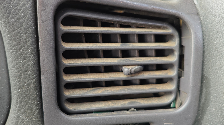 A dirty air vent in an old car