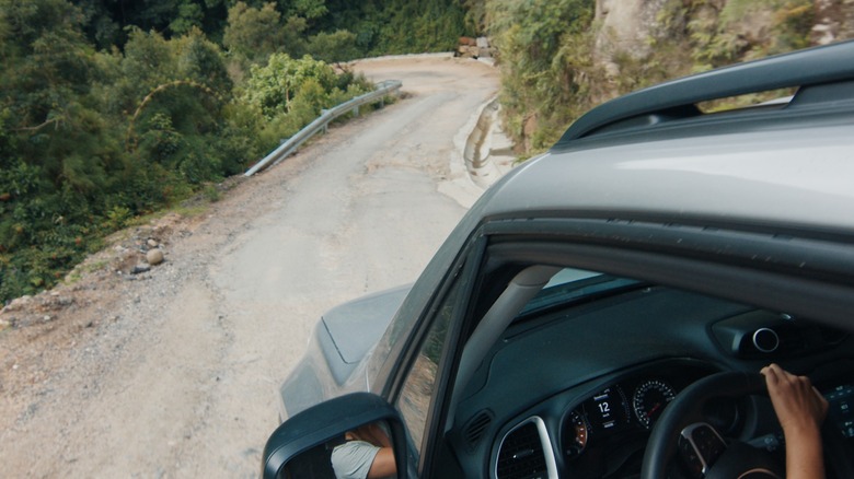 A driver negotiates a treacherous downhill section of road.