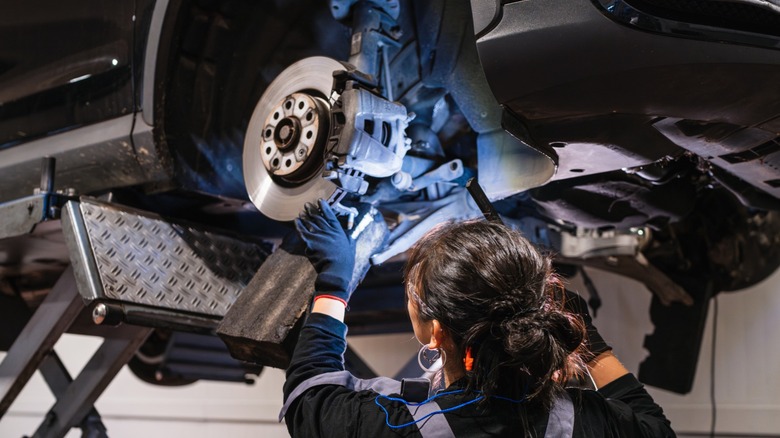 A mechanic inspecting a car's brakes.