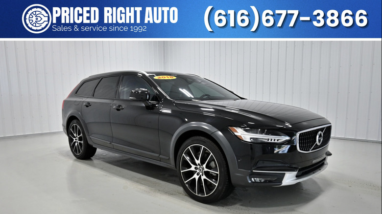 a black volvo v90 parked in a dealership room