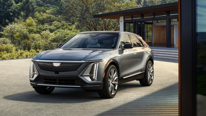 a cadillac lyriq parked outside of a modern looking home
