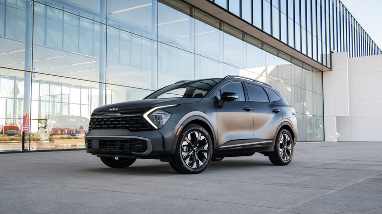 A kia sportage parked in front of a glass office building