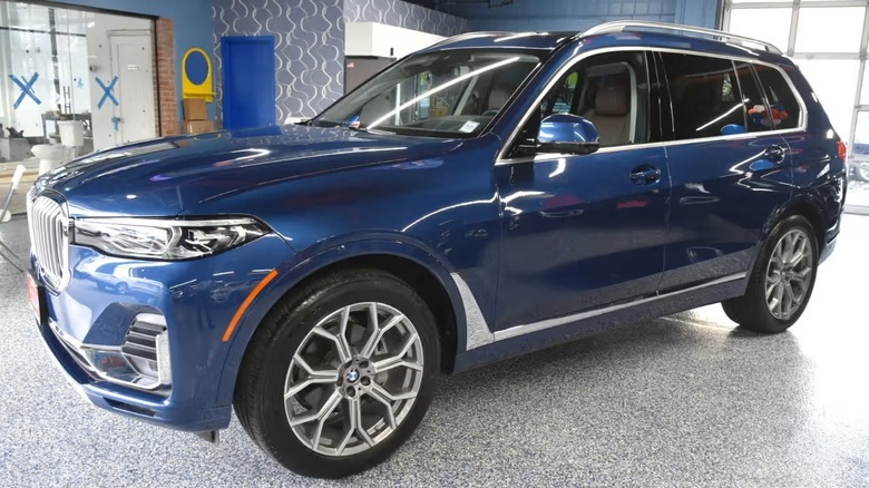 a blue 2020 BMW X7 xDrive 40i sitting on a showroom floor