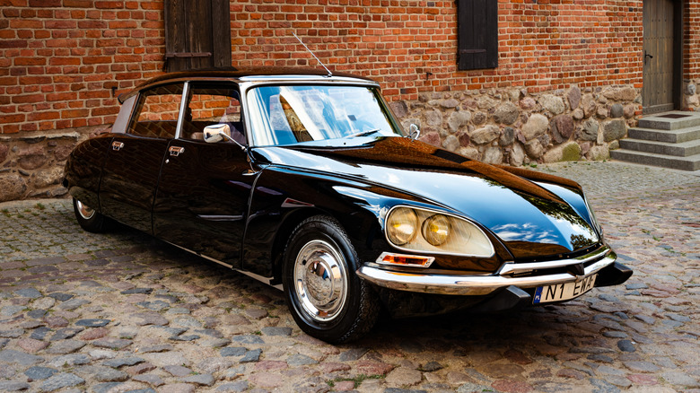 A black Citroen DS parked on cobblestones