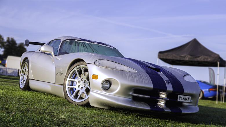 A silver Dodge Viper parked at a car show on a sunny day