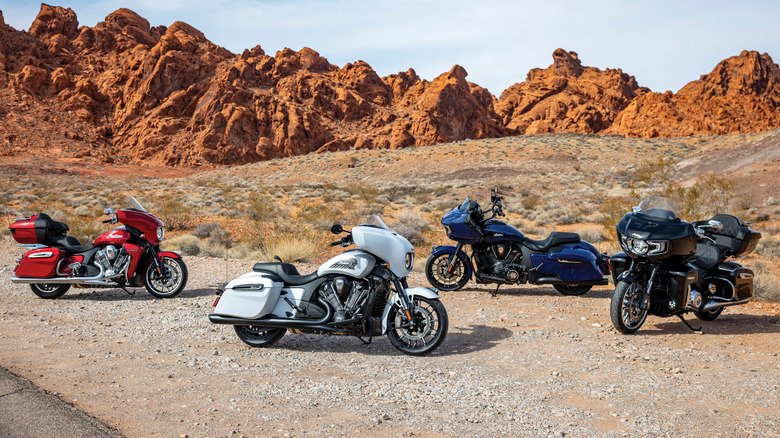 Four Indian dressers in the dirt off the side of a desert road
