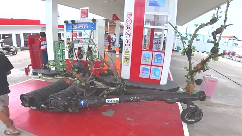 The log-constructed Extreme Vespa on full display while filling up at the gas station.