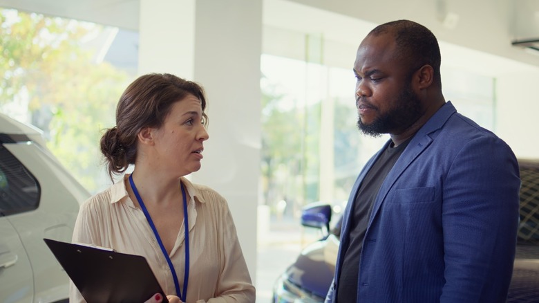 Car salesperson having a discussion with a customer.