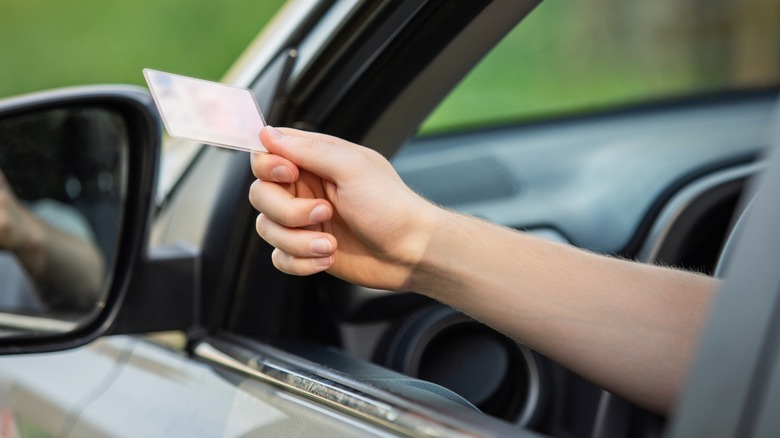 Closeup of driver's hand as they show their driver's license at a traffic stop