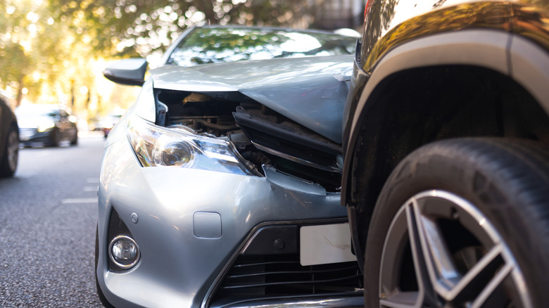A silver sedan rear-ended a black SUV.