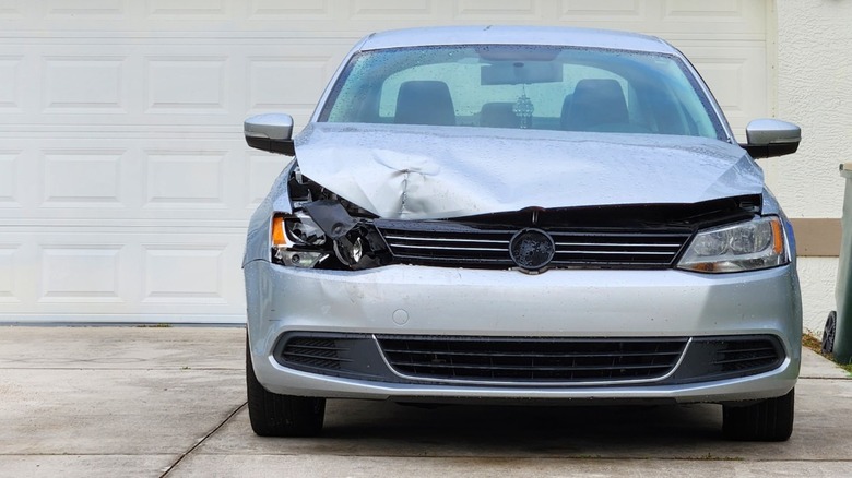 A wrecked car parked successful a driveway