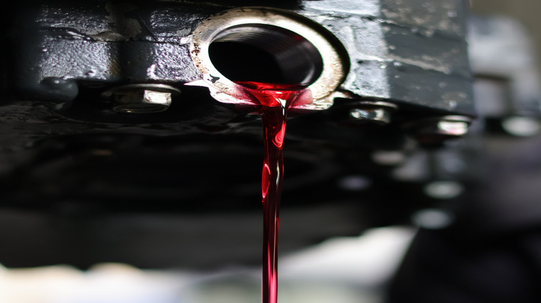 Removing the drain plug from the ATF drain hole to flush out the old fluid