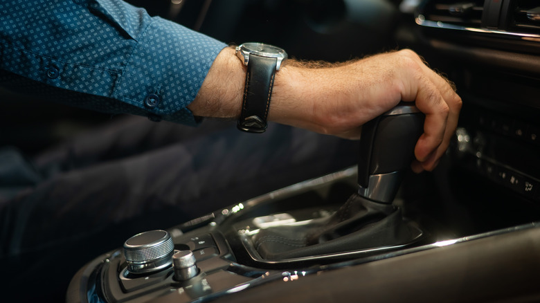 Driver's hand grasping the automatic transmission shift lever