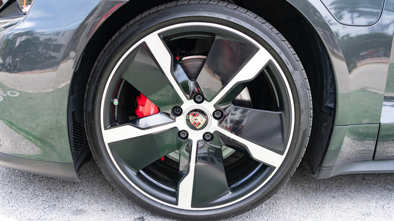 A Porsche Taycan's beforehand near wheel, showing reddish brake calipers