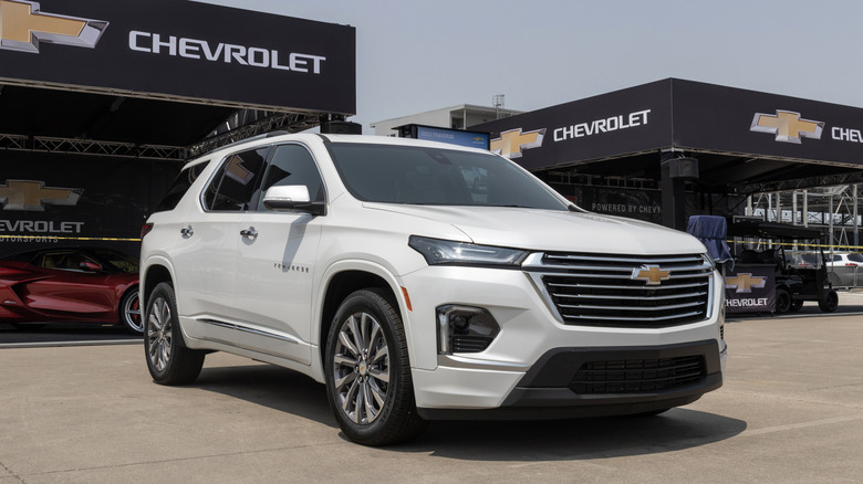 A 3/4 front-right shot of a white Chevrolet Traverse with Chevrolet tents in the background