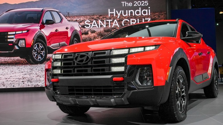 A red Hyundai Santa Cruz on display at an auto show.