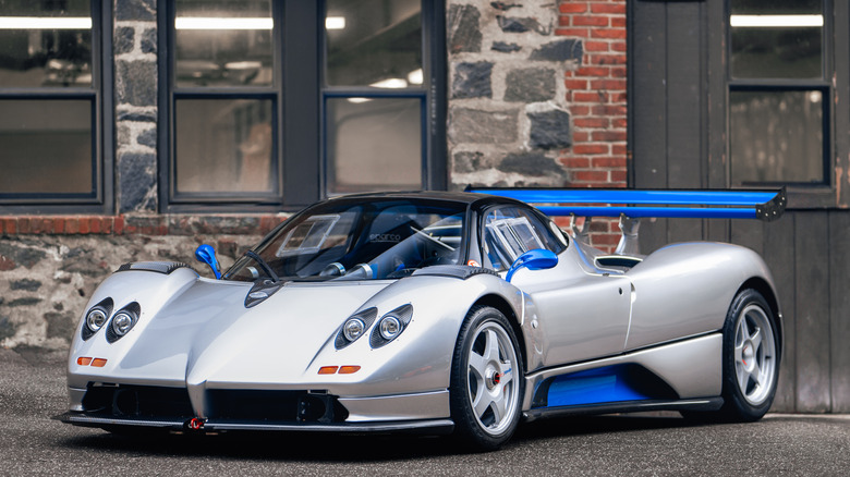 A front-quarter shot of a gray and blue Pagani Zonda C12 S Monza parked in front of a brick building