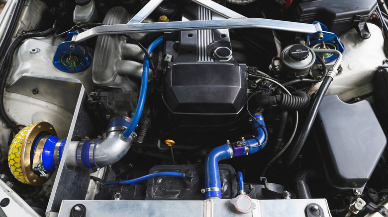 A race-prepped engine with blue silicone hoses for the radiator and air intake