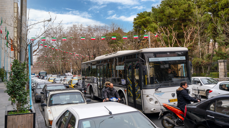 A traffic jam filled with cars, scooters, and a bus in Tehran, Iran.