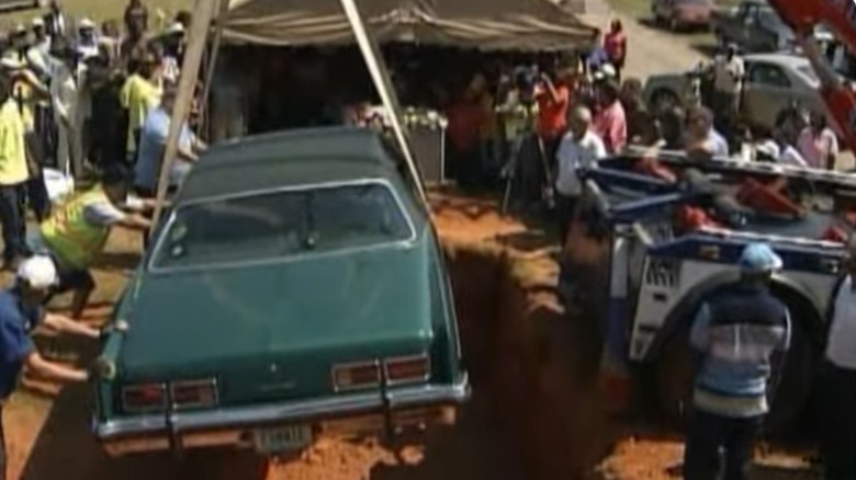 Lonnie Holloway and his 1973 Pontiac Catalina being lowered into grave.