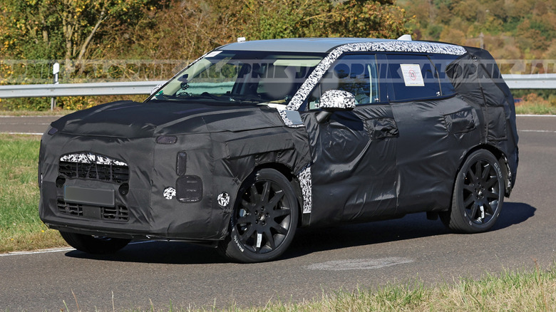 Front 3/4 view of a camouflaged 2028 Kia Sportage