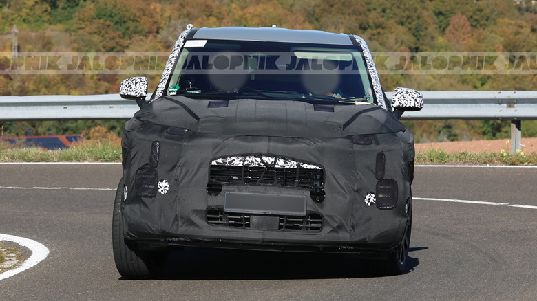 Front end of a camouflaged 2028 Kia Sportage prototype