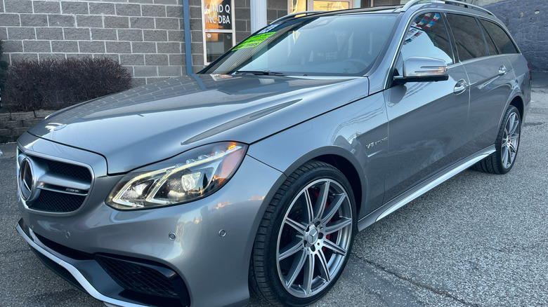 a silver Mercedes-Benz E63 S AMG wagon parked in front of a building