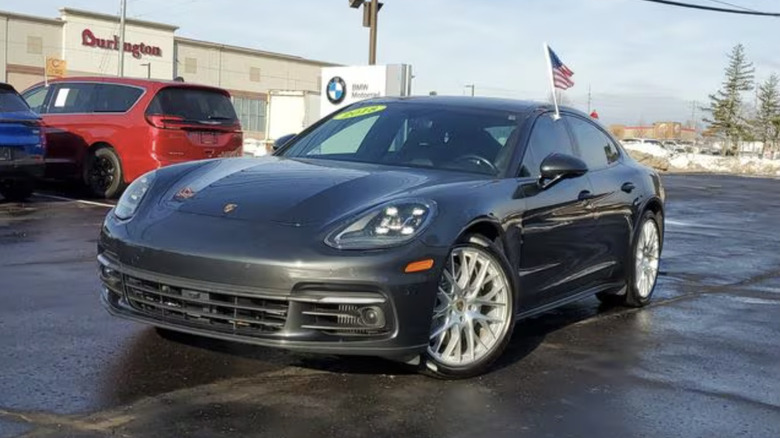 a black 2018 Porsche Panamera 4S parked in a parking lot with snow in the background