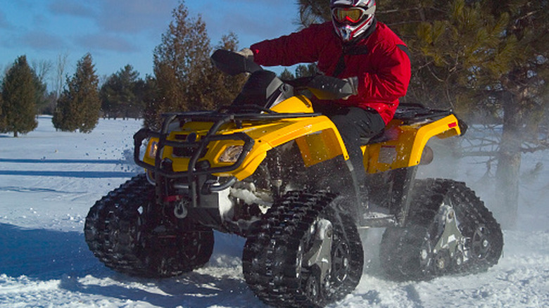 An ATV with a track kit installed on the snow