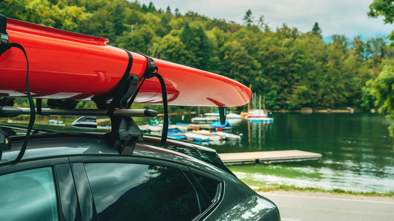 Surfboards on a car's roof rack near a lake.