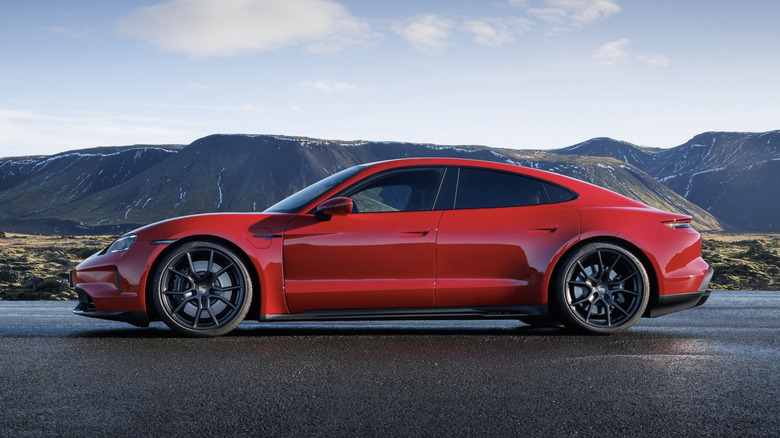 Red porsche parked on a wet road in the mountains