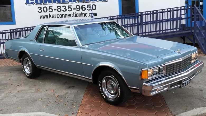 A blue 1978 Chevrolet Caprice Classic parked next to a building