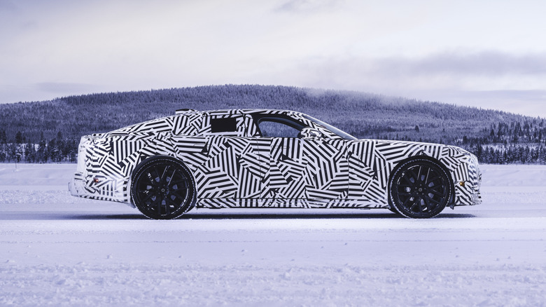Side view of a camouflaged Jaguar GT prototype in the snow