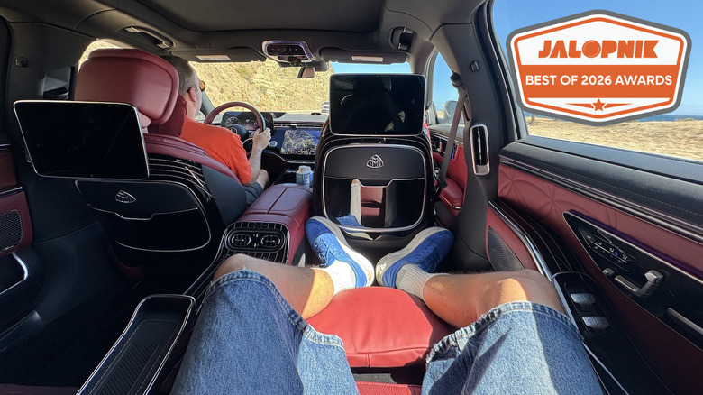 a man reclines in the back of a plush Mercedes Maybach S-Class while passing a beach