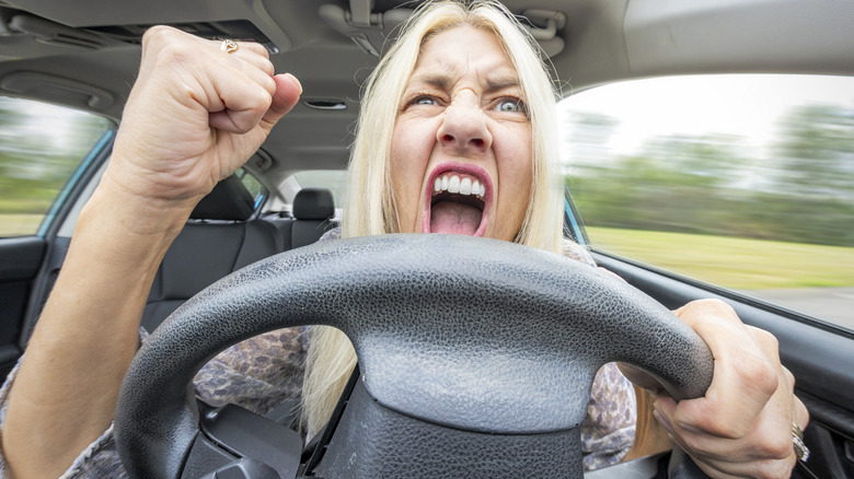 A blonde woman yelling while driving