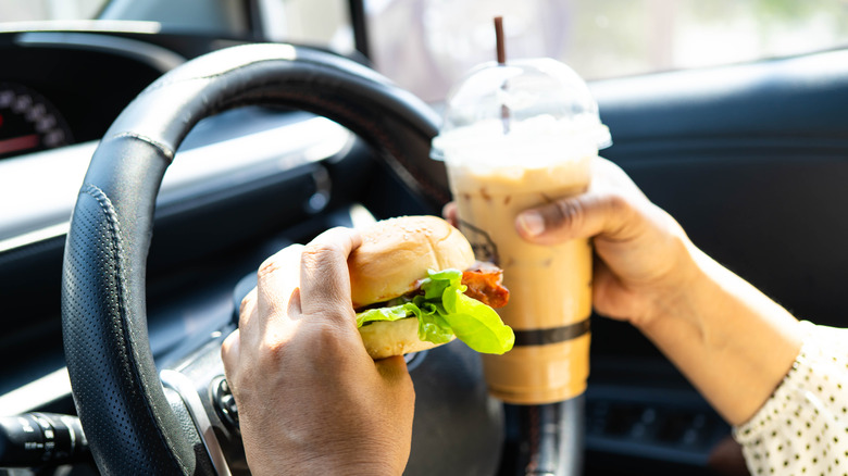 Holding a burger and drink while driving