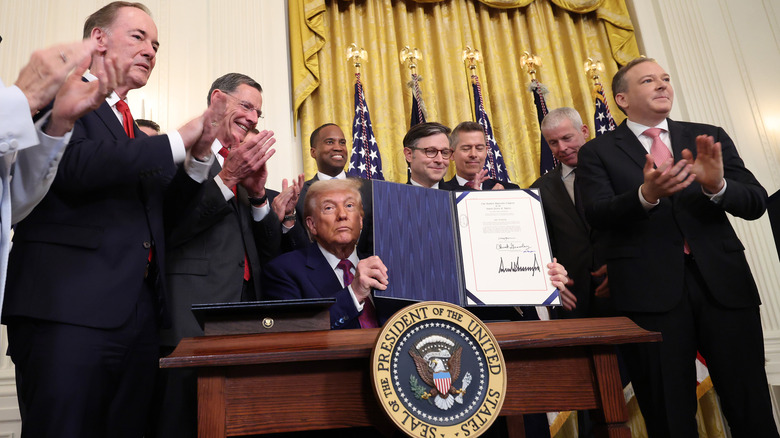 U.S. President Donald Trump, joined by applauding lawmakers, holds up an executive order after signing a series of bills related to California's vehicle emissions standards during an event in the East Room of the White House on June 12, 2025 in Washington, DC.