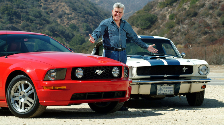 Jay Leno with his classic white Shelby Mustang and a more modern red Ford Mustang