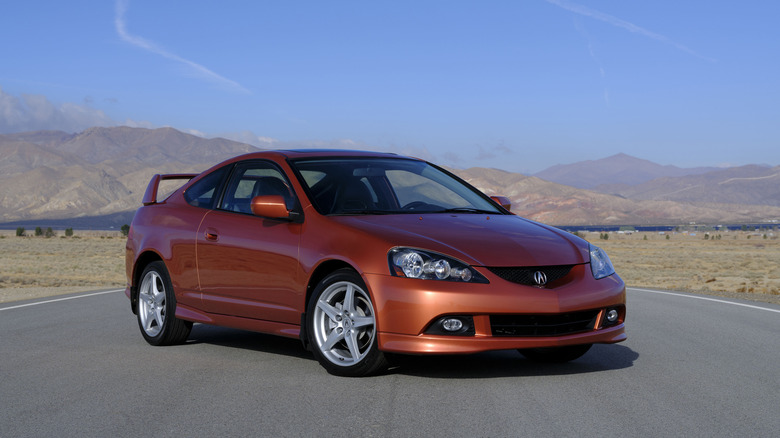 An orange metallic 2006 Acura RSX Type S parked on a road