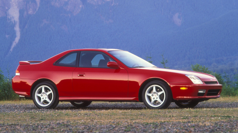 A red 1998 Honda Prelude SH parked on dirt